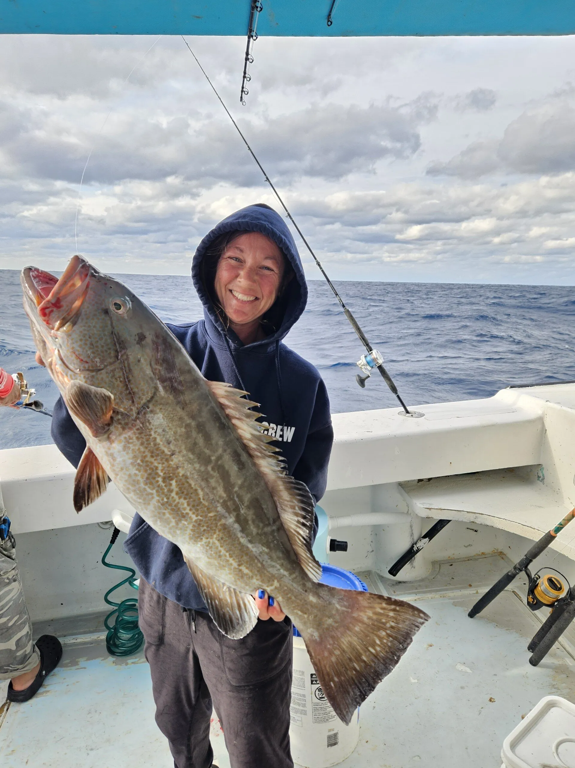 Angler in a hoodie with a grouper