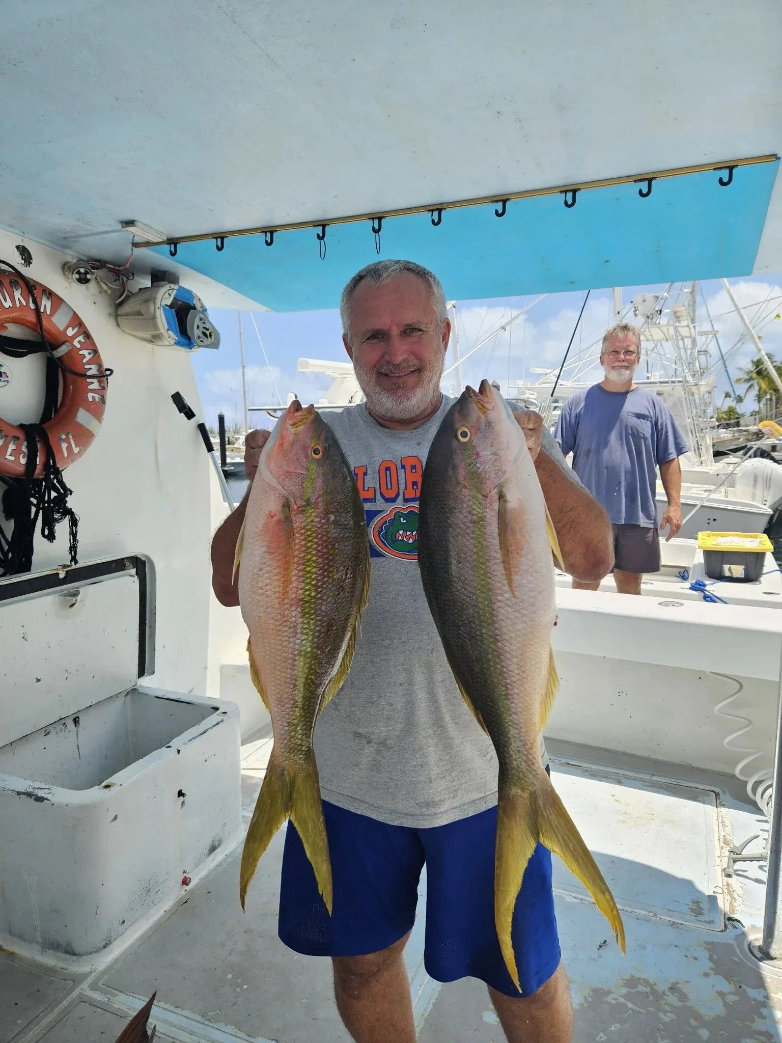 Angler with two yellowtail snapper on deck
