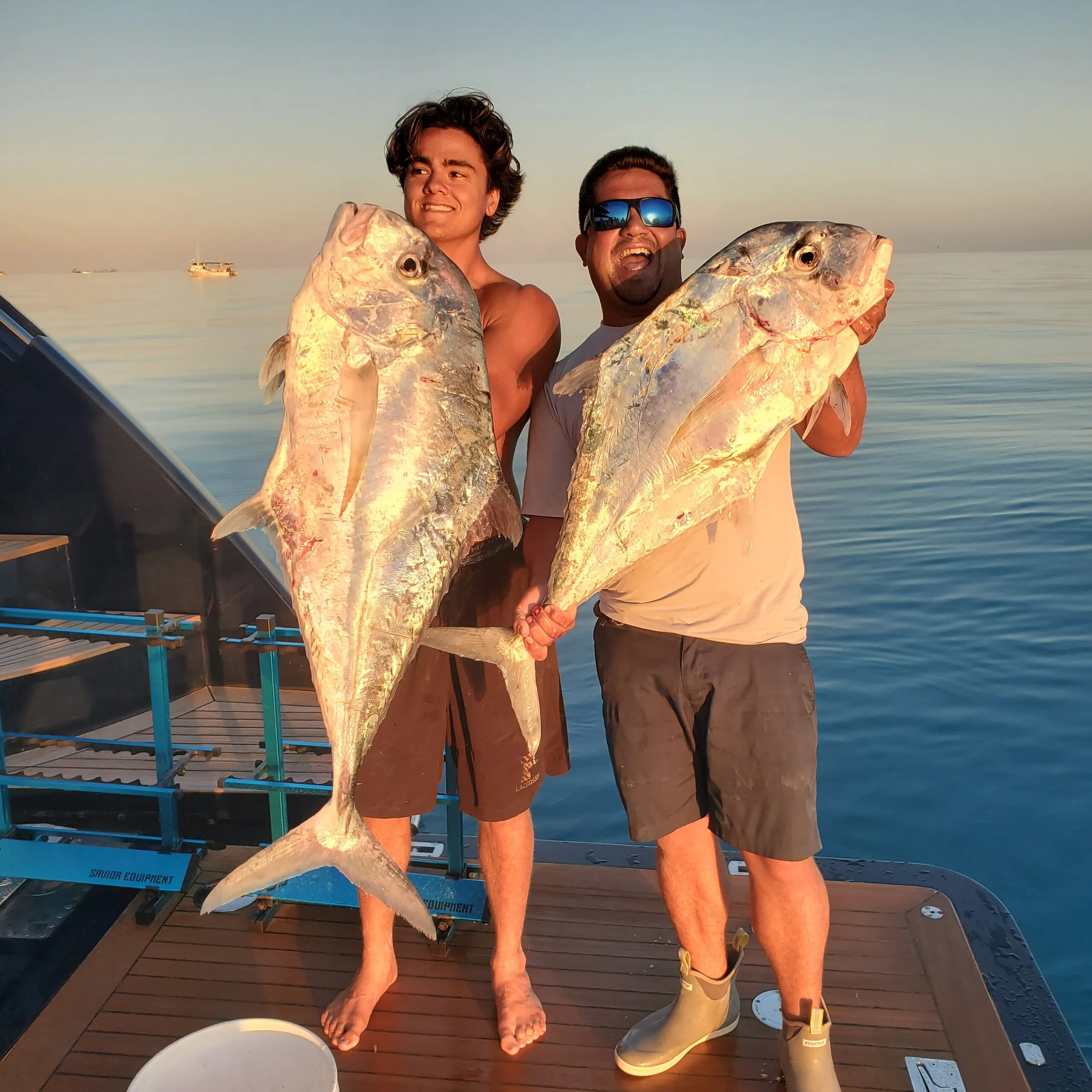 Two anglers with jacks at sunset
